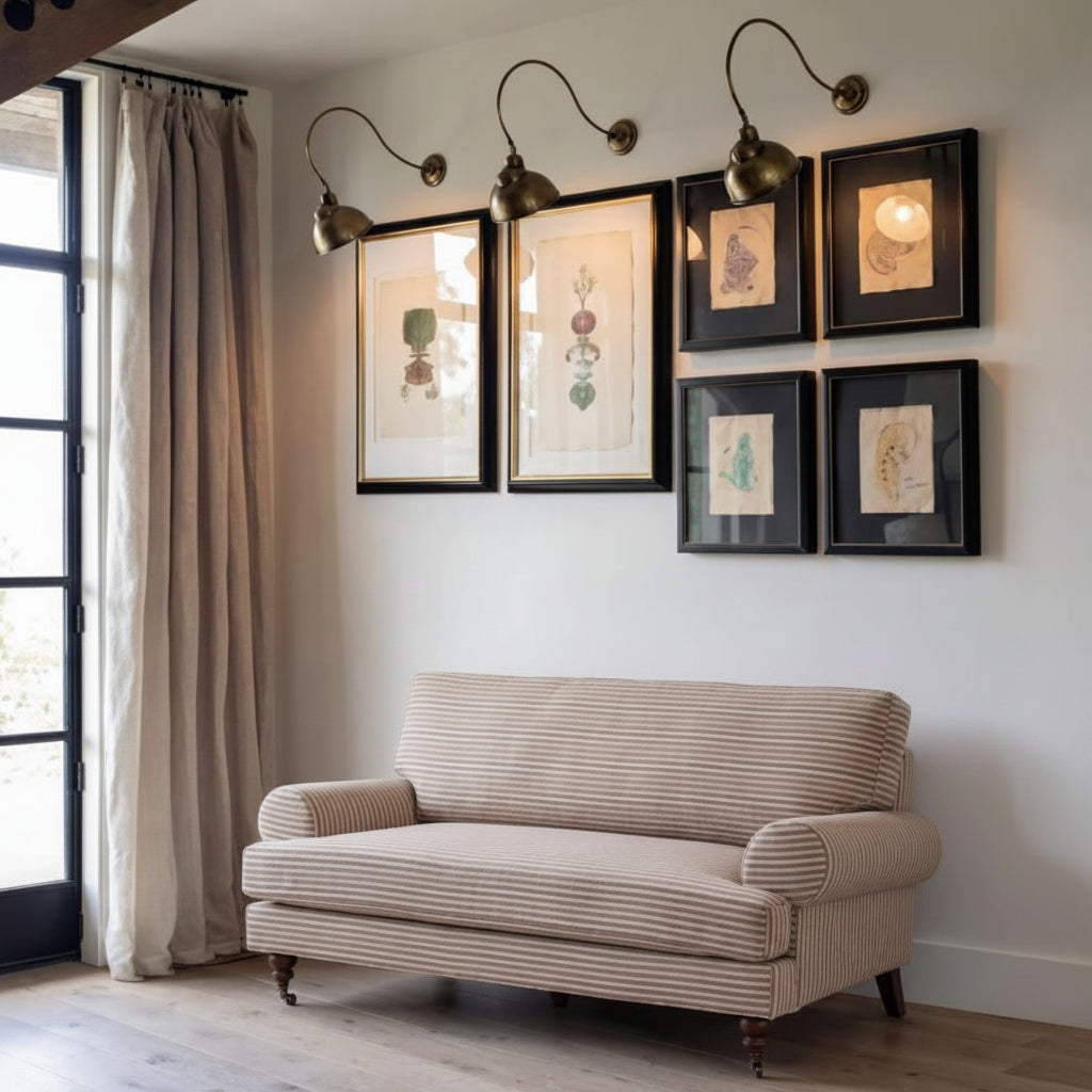 Beige sofa in a room with wall art and lighting fixtures.